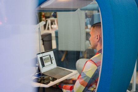 Mann in einem Besprechungspod am Laptop