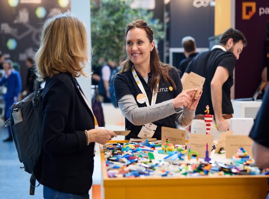 Zwei Frauen an einem Messestand mit Lego